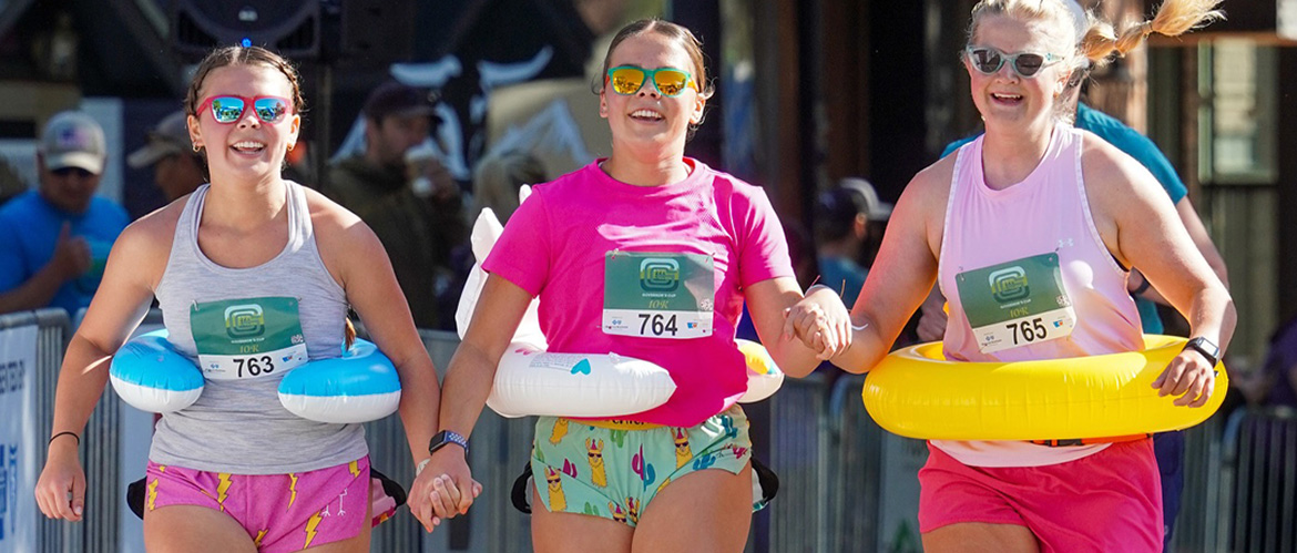 Three women with intertubes run in the 2025 Montana Governor's Cup