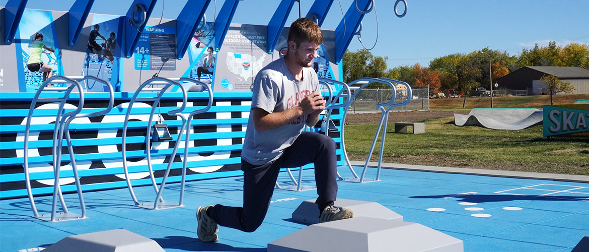 young man with blonde hair excercises on outdoor fitness court